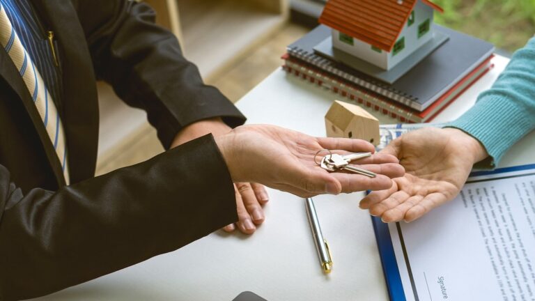 landlord handing over the keys after reviewing rental screening report
